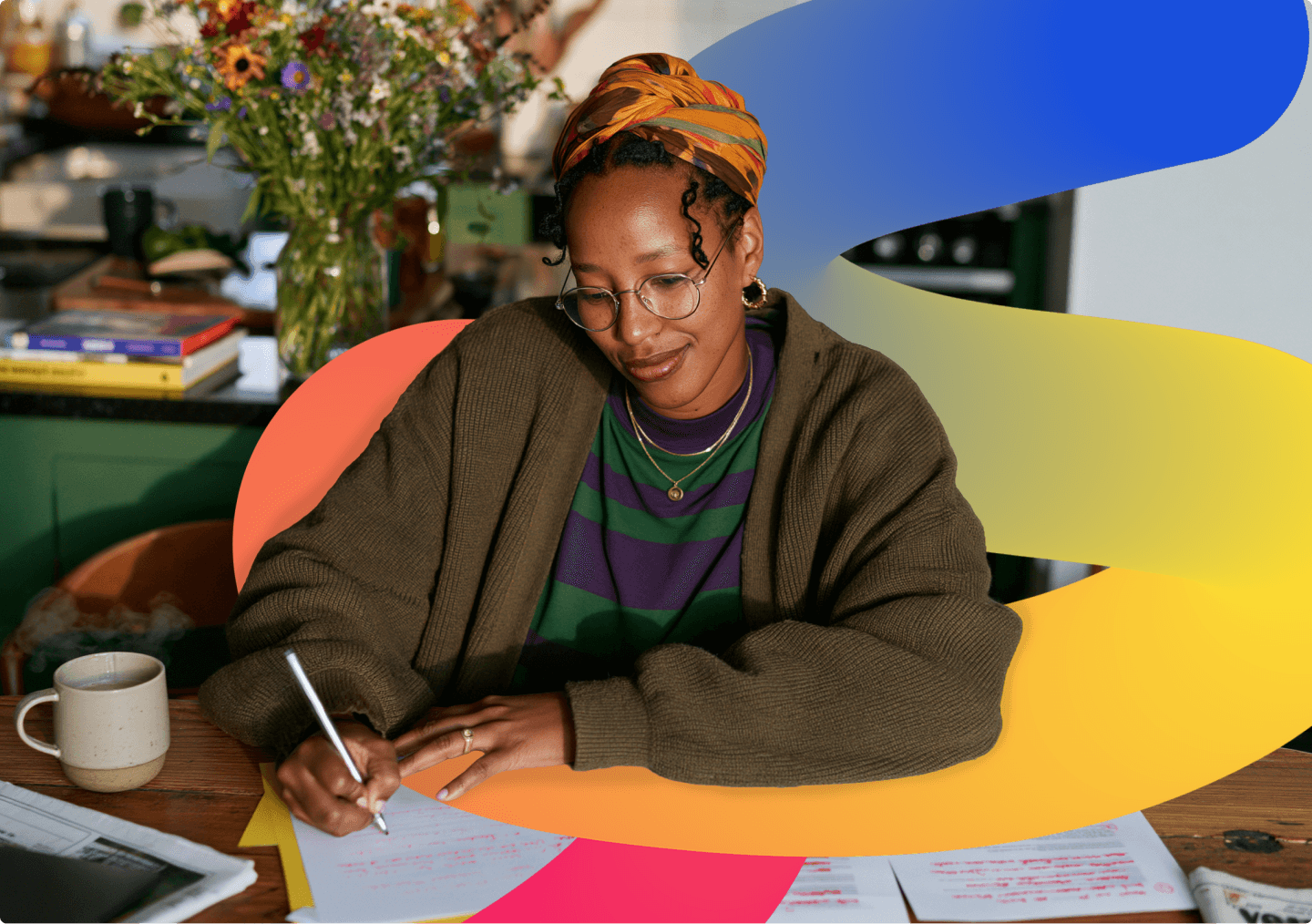 A designer writing in a notebook at her studio desk.